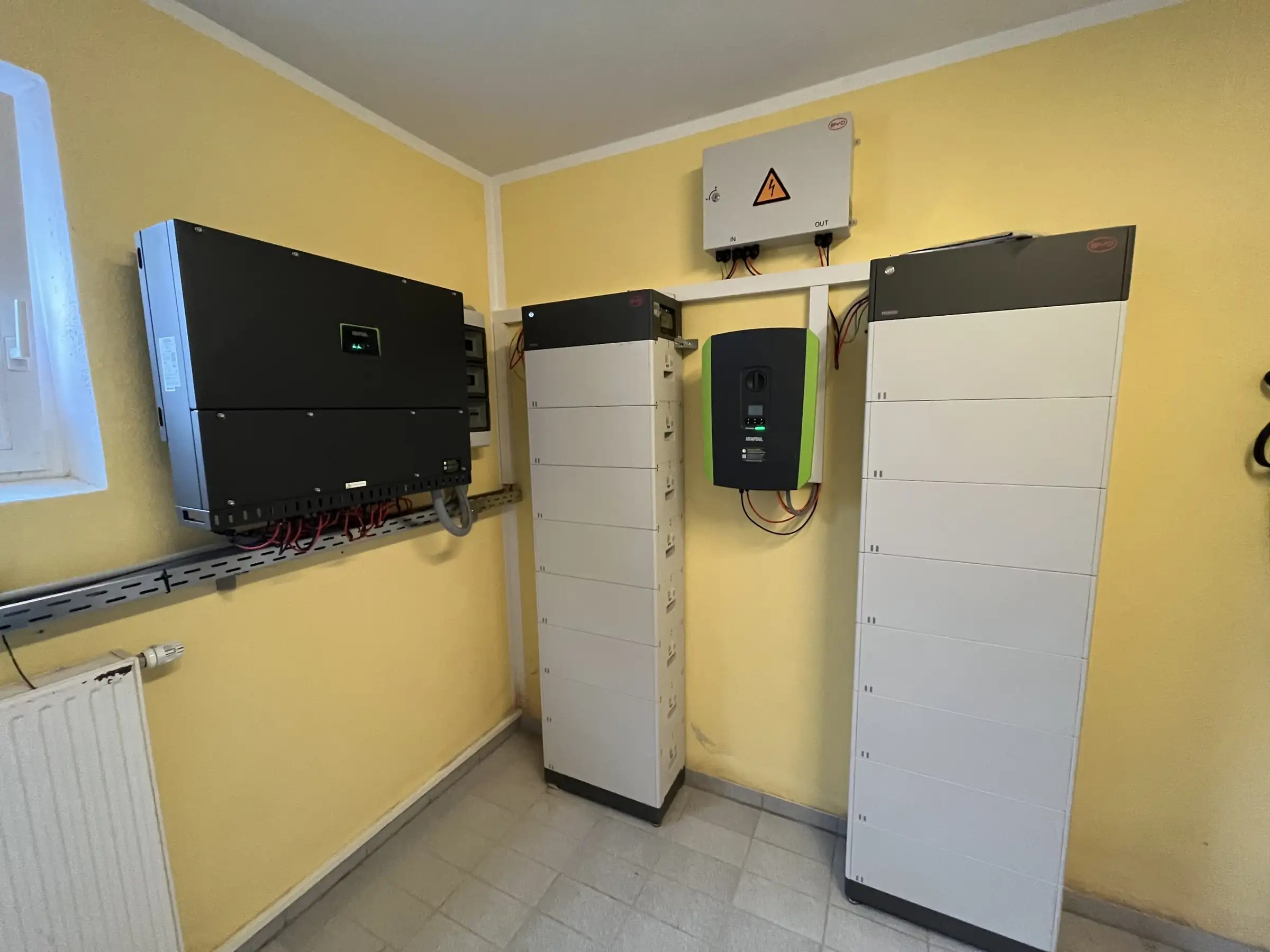 Wechselrichter und Batteriespeicher an der Wand eines Technikraums